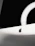 A close-up photo of a sleek black screen mount holding a flat monitor against a white wall.