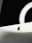 A close-up photo of a sleek black screen mount holding a flat monitor against a white wall.