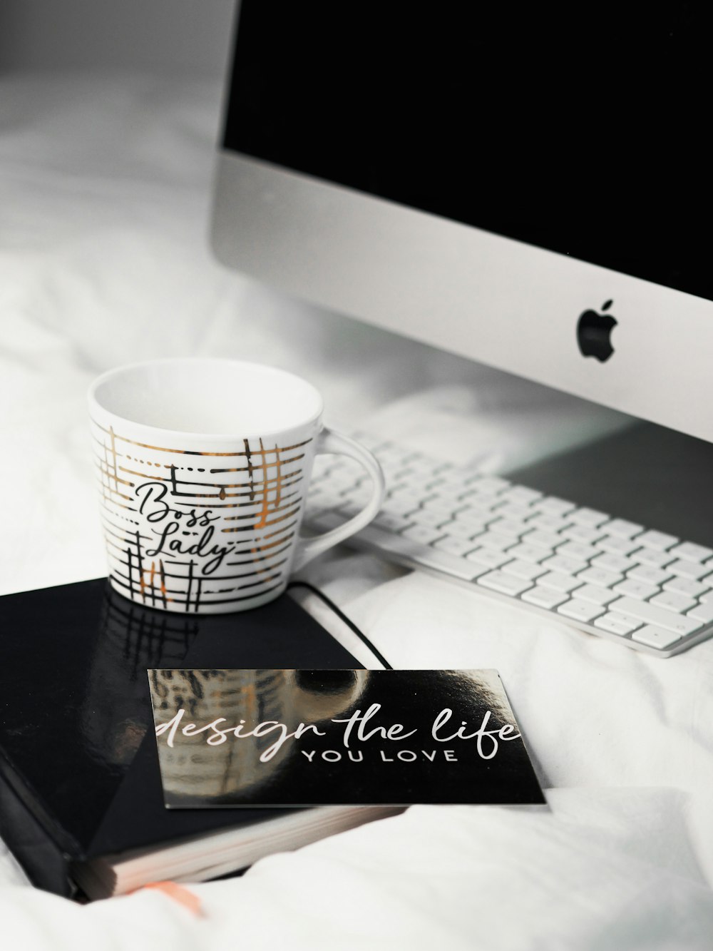 white and black ceramic mug beside white computer keyboard