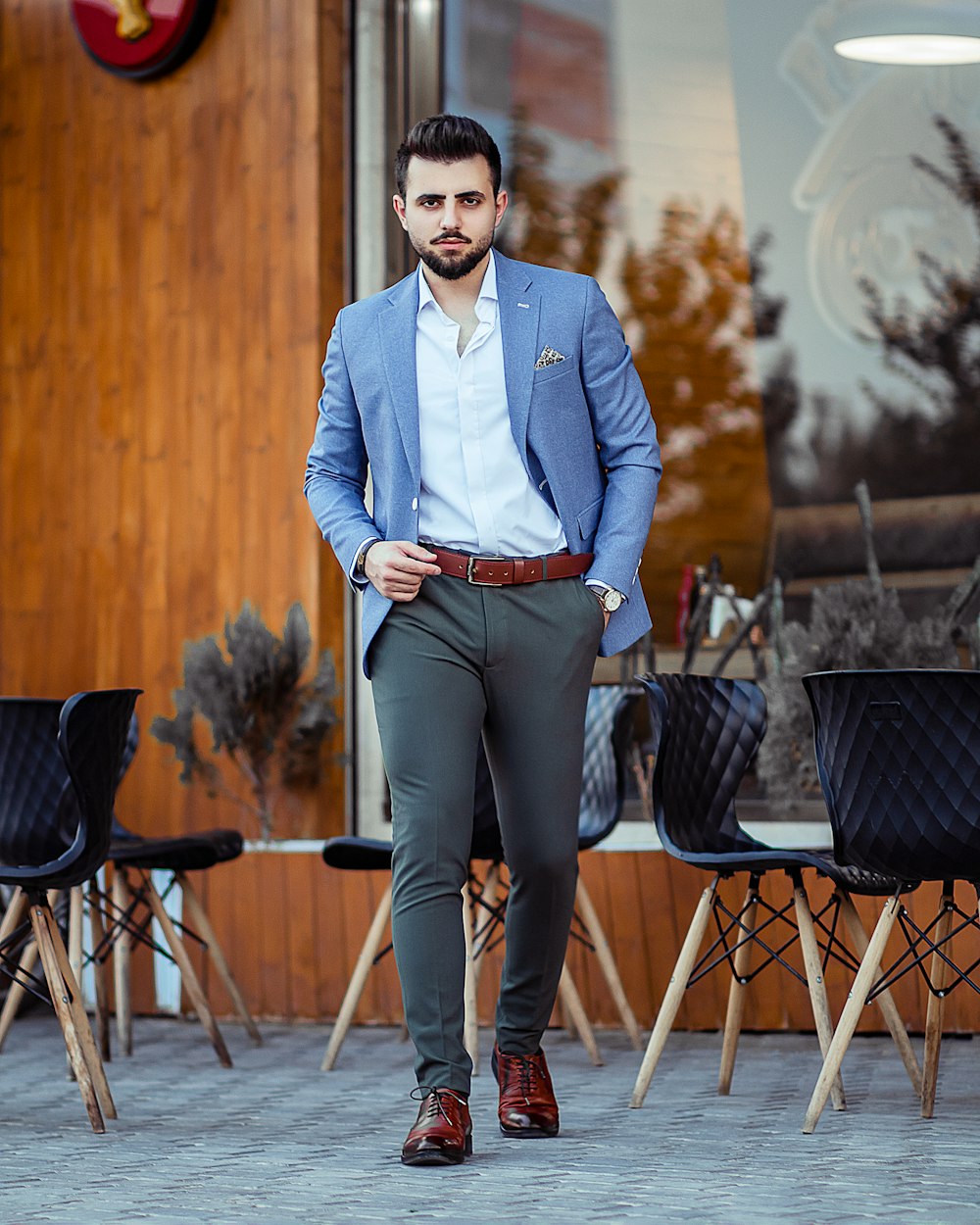 man in blue dress shirt and black pants sitting on chair