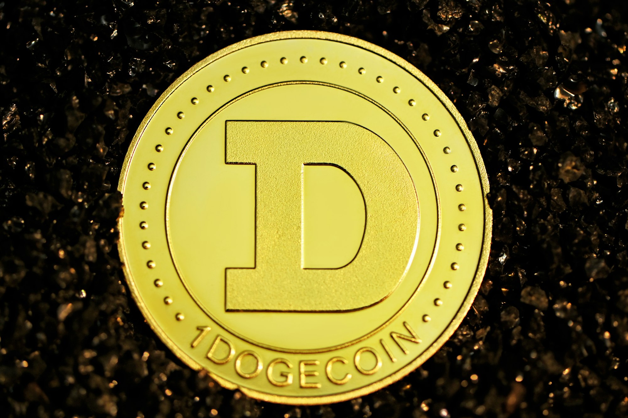 A Dogecoin faces up on a black stoned surface.
