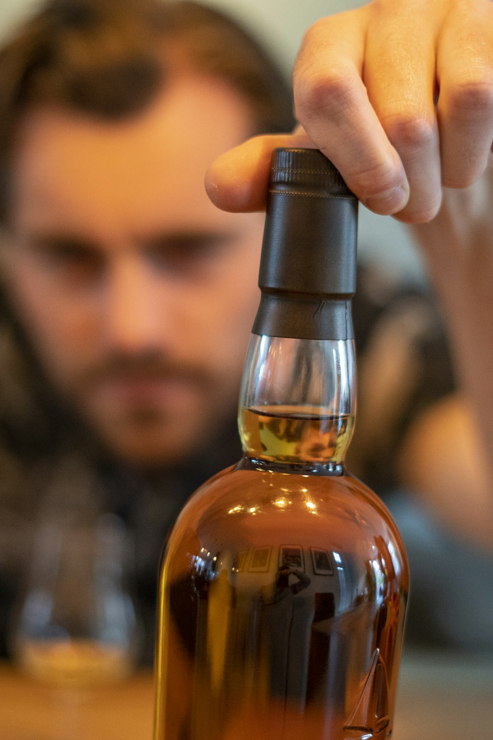 person holding clear glass bottle