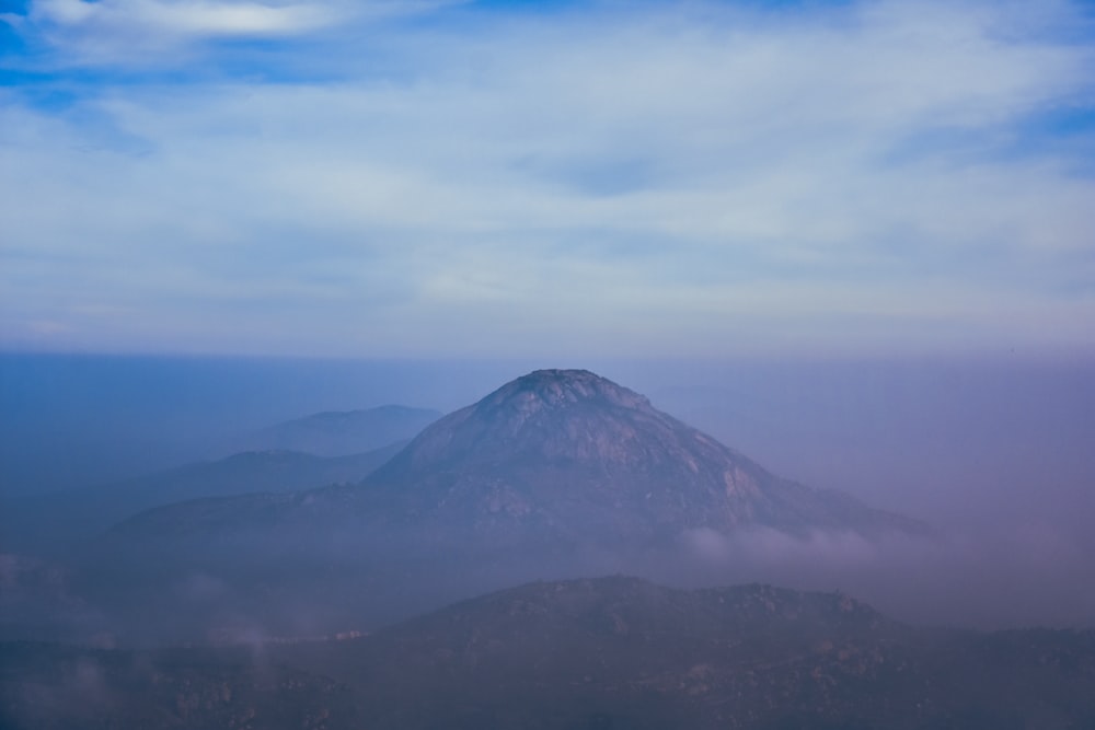 green mountain under white clouds during daytime