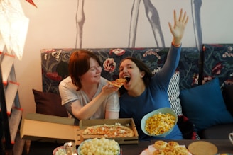 Friends gathered on a couch, enjoying a movie night together with snacks and laughter.