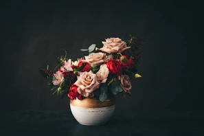 pink and white roses in white ceramic vase
