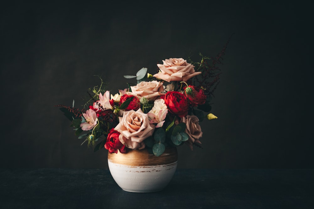 pink and white roses in white ceramic vase