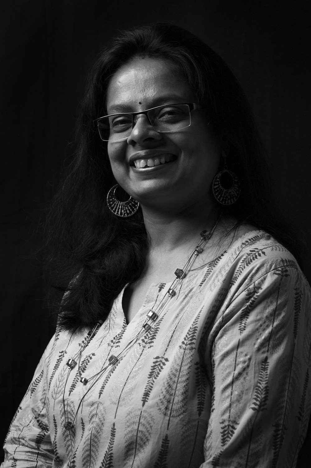 woman in white and black floral shirt wearing eyeglasses
