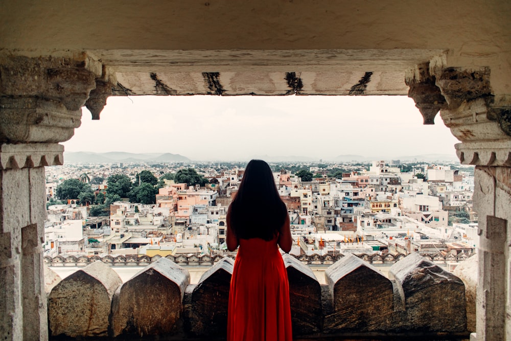 person in red hoodie standing on top of building during daytime