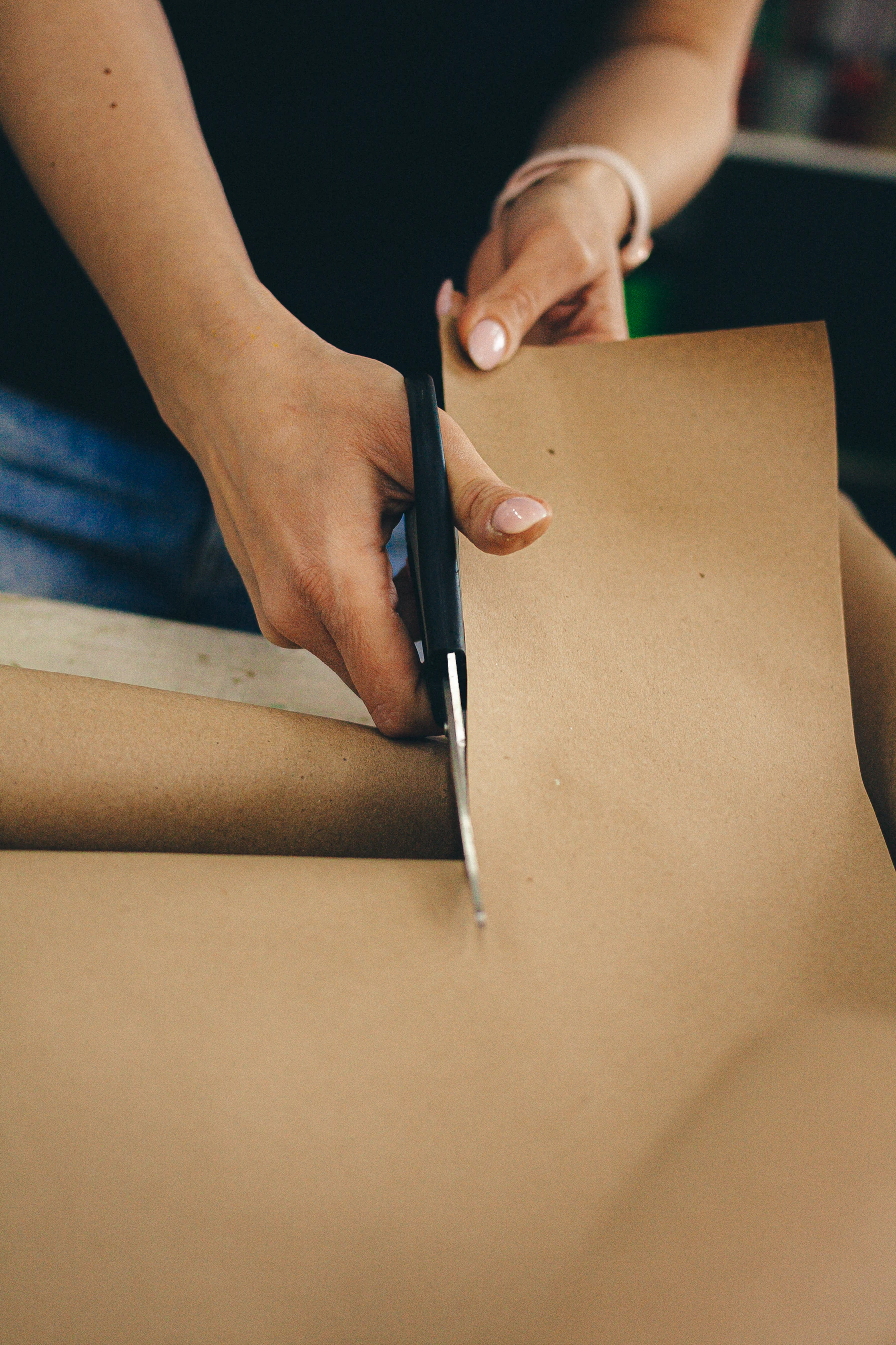 a person cutting a piece of cardboard with a pair of scissors
