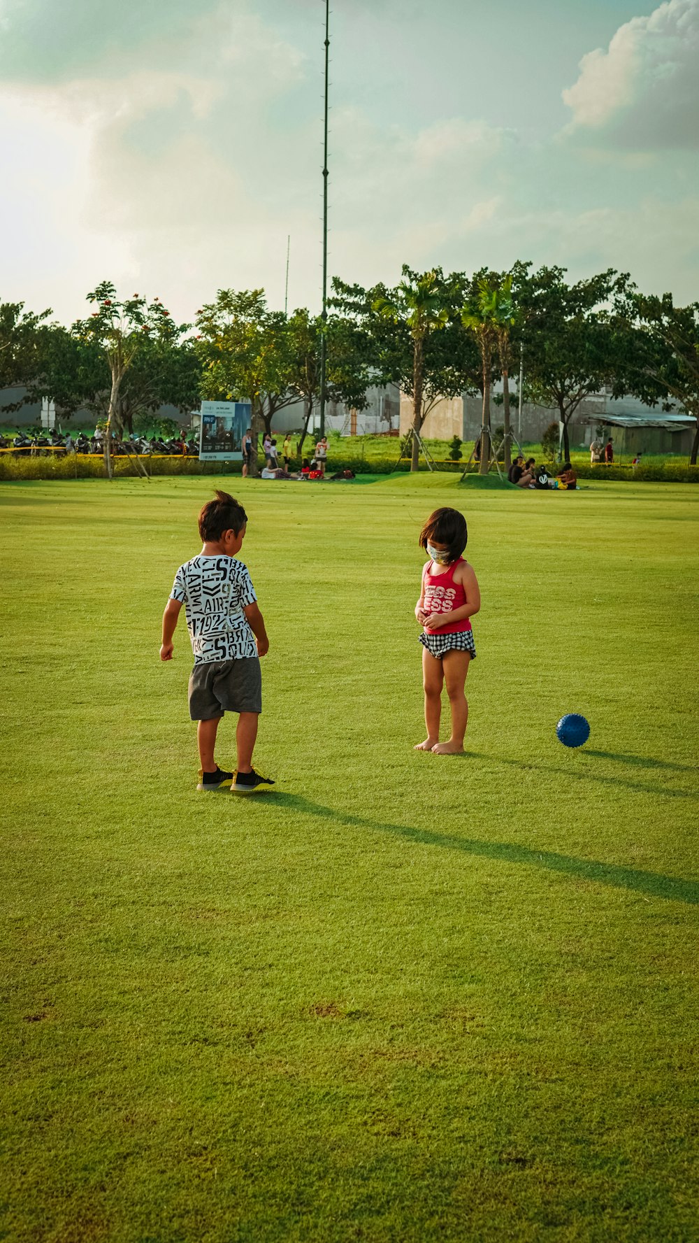 2 boys playing soccer on green grass field during daytime