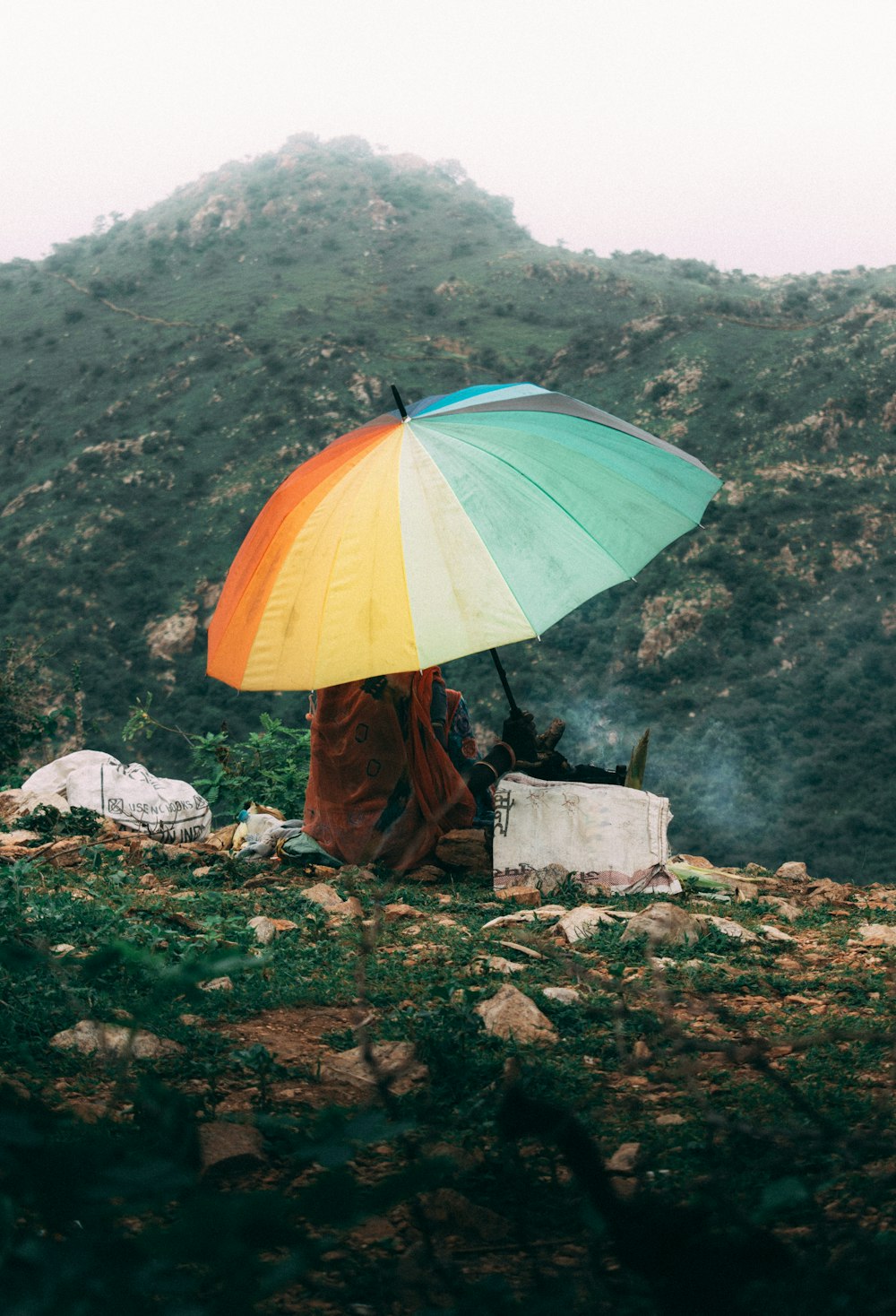 person in orange dress holding umbrella standing on green grass field during daytime