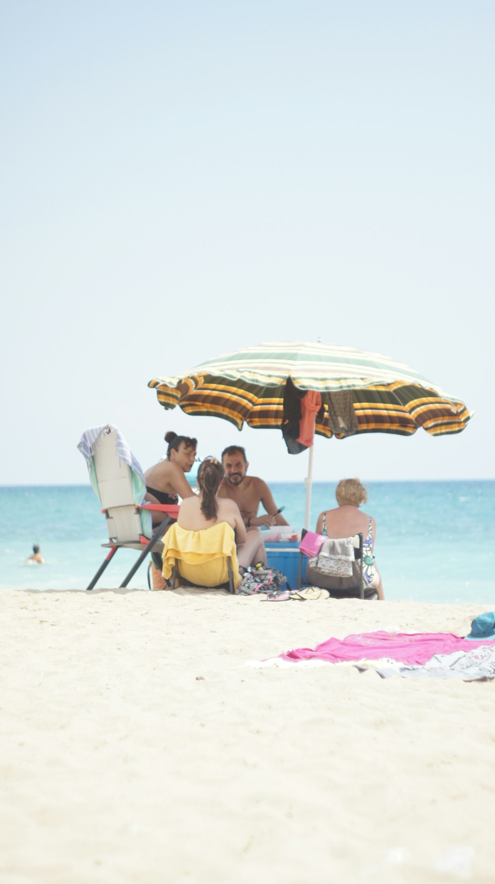 personas sentadas en sillas de playa en la playa durante el día