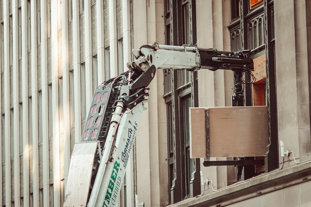 man in black jacket standing on ladder