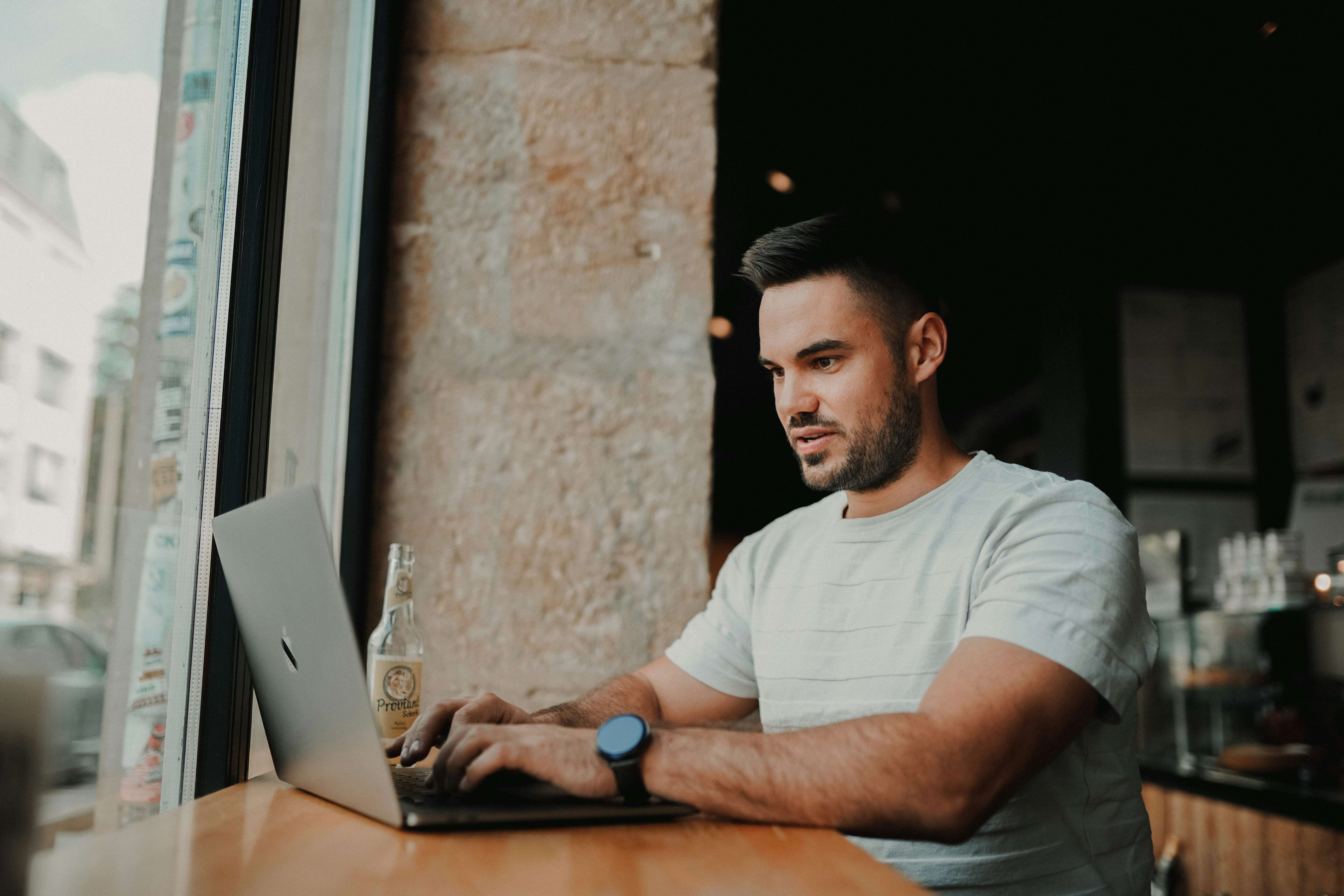 man in white crew neck t-shirt using laptop computer