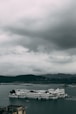 white boat on sea under gray clouds