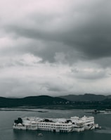 white boat on sea under gray clouds