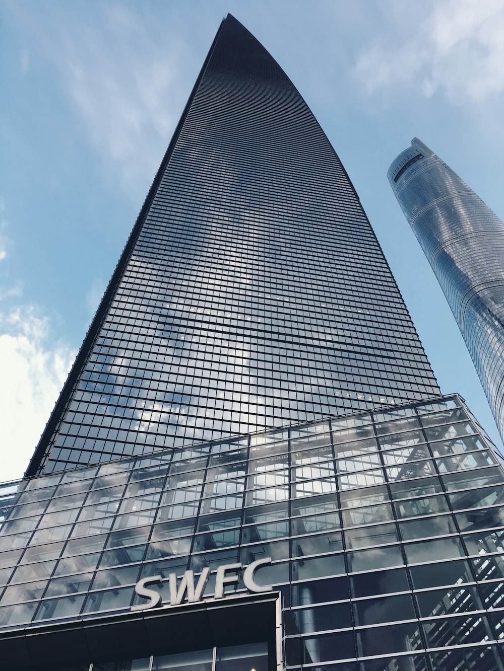 Fotografía de ángulo bajo de un edificio de vidrio bajo el cielo azul durante el día