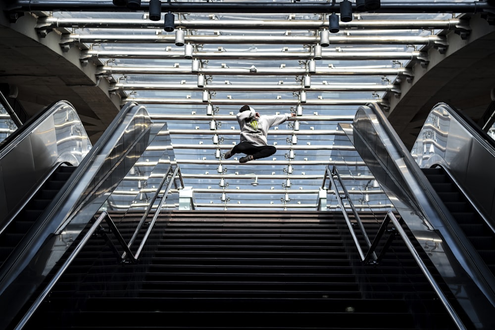 man in green jacket and black pants sitting on gray stairs