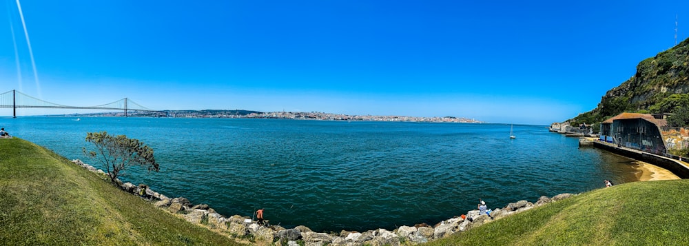 people standing on gray rock formation near body of water during daytime