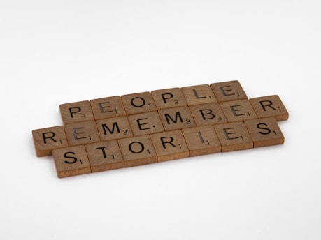Wooden Scrabble tiles spelling 'People Remember Stories