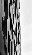 Elegant modern building facade showcasing shadows and geometric shapes.