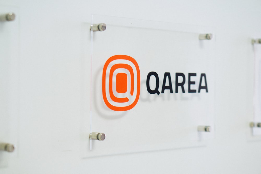 a glass sign with a qarea logo on it