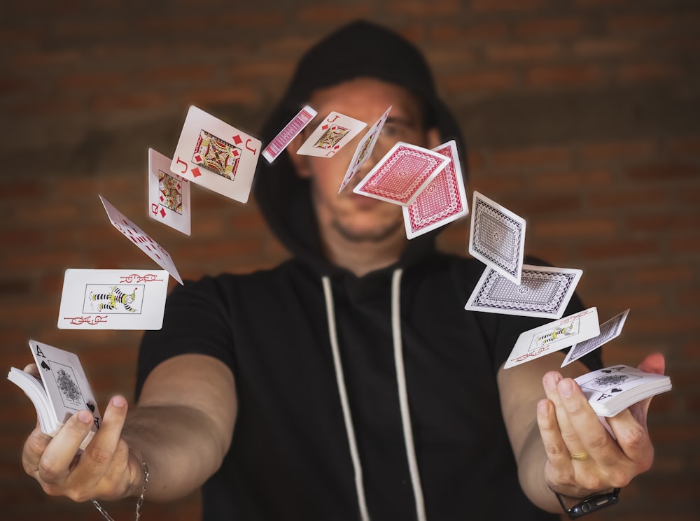 woman in black and white crew neck t-shirt holding playing cards