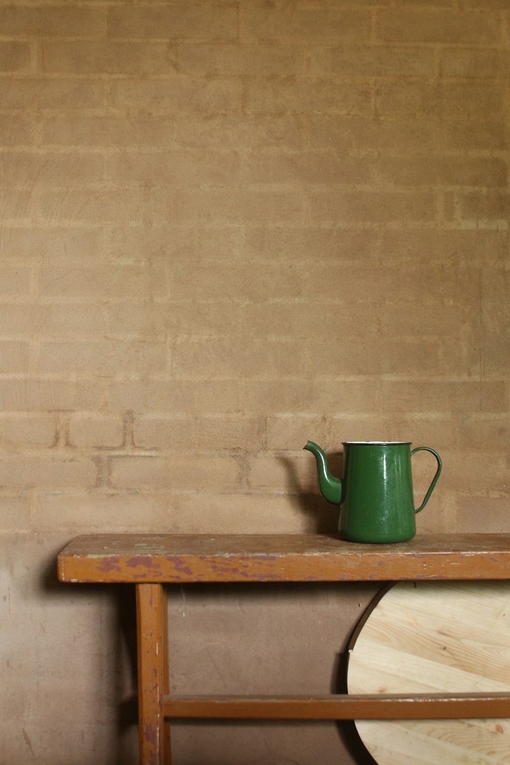Taza de cerámica verde sobre mesa de madera marrón