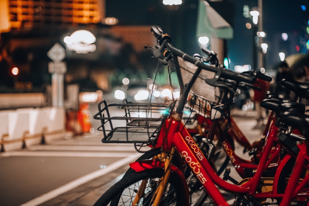 red and black city bikes parked on sidewalk during daytime