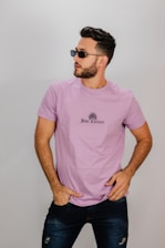 man in pink crew neck t-shirt wearing black sunglasses
