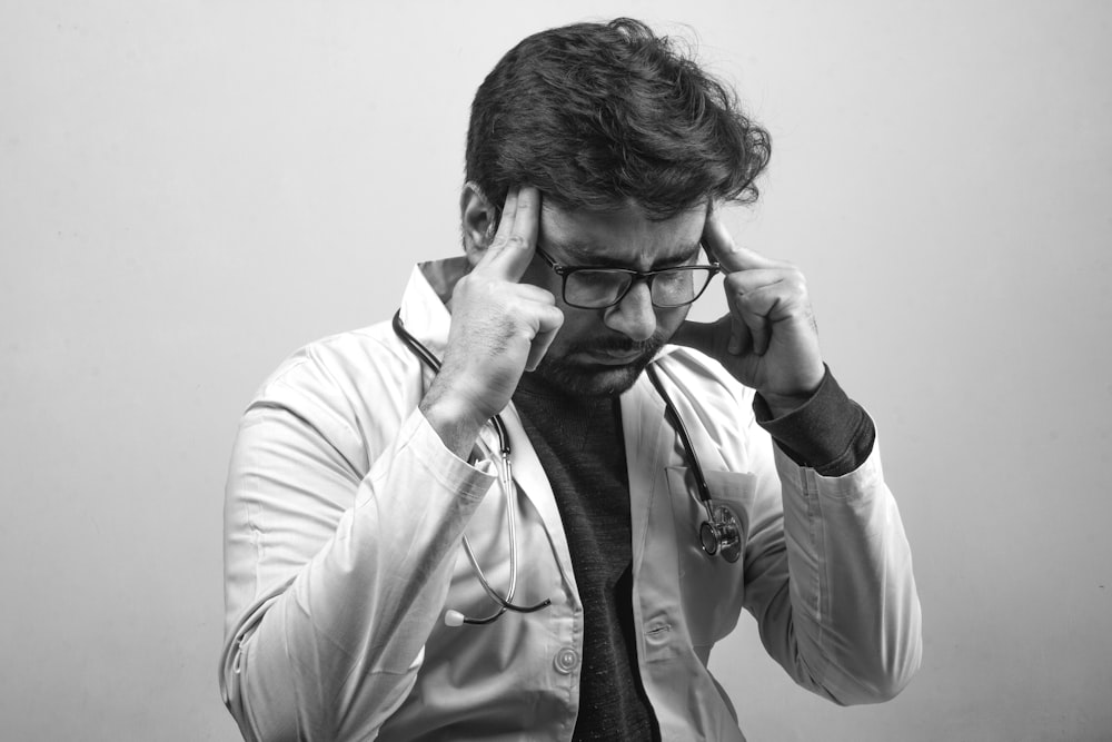 Homme en chemise blanche portant des lunettes à monture noire