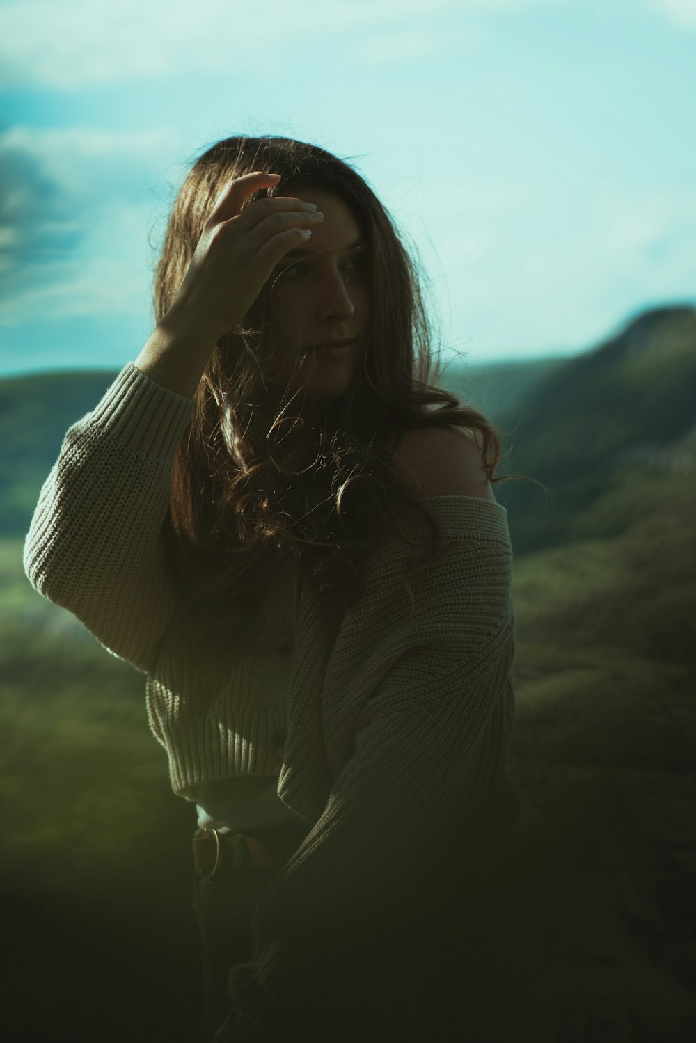 woman in white long sleeve shirt standing on green grass field during daytime