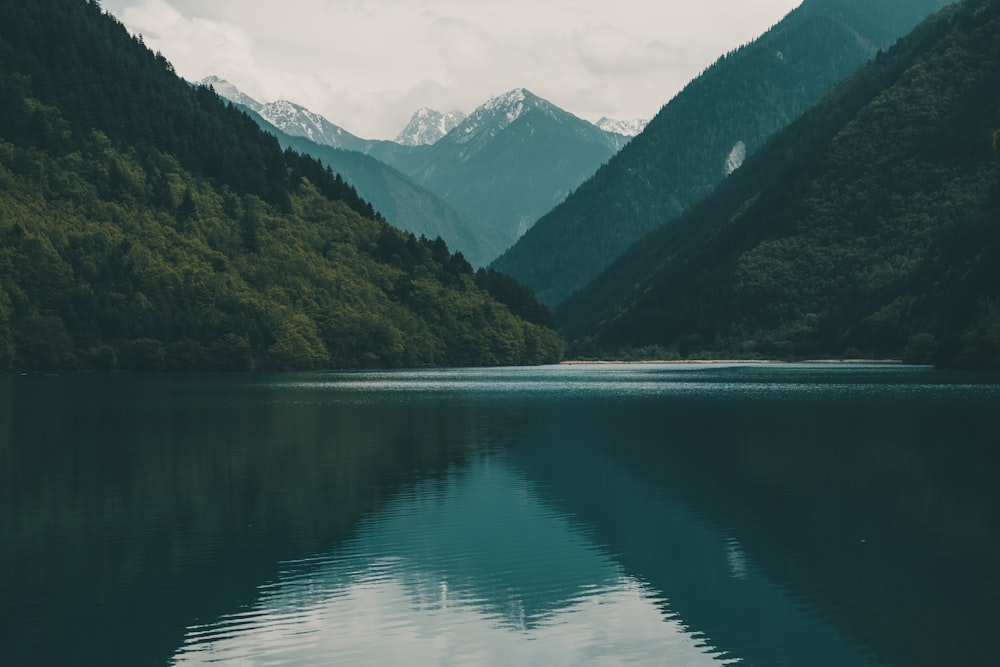 green mountains beside body of water during daytime