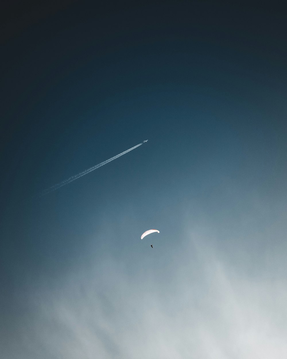 person in parachute under blue sky during daytime