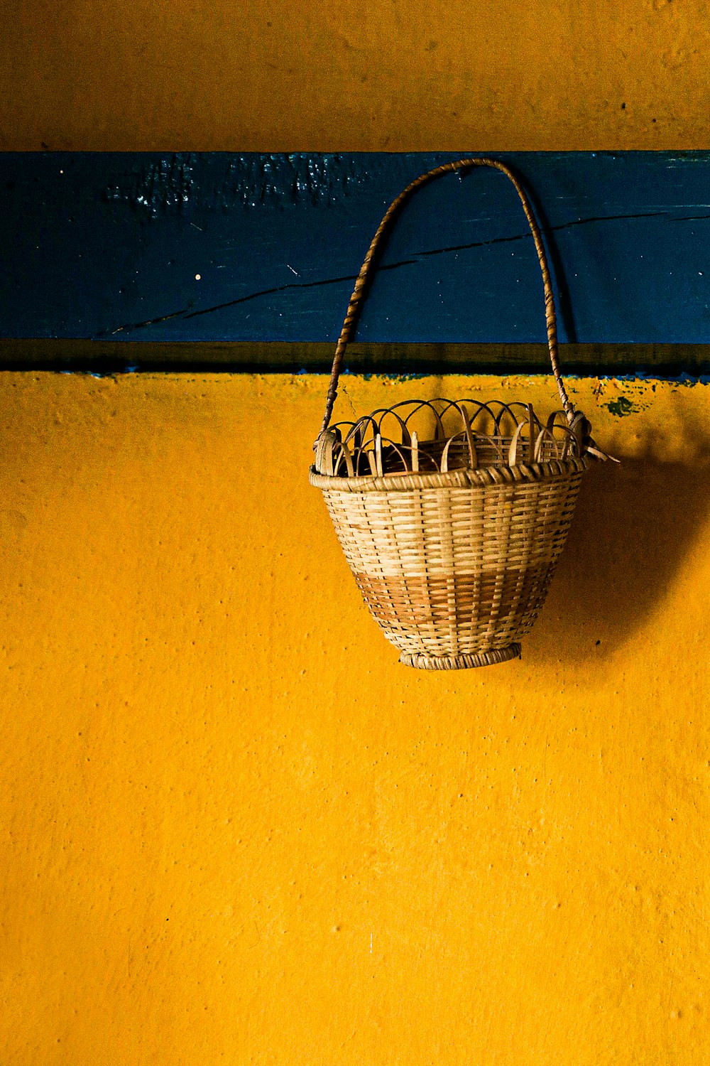 黄色い壁に茶色の織りバスケット