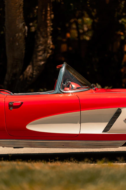 A shiny red convertible with the top down, perfect for a weekend getaway.