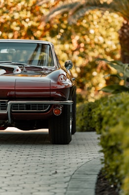 A shiny burgundy sedan parked in front of the Marvelous Auto dealership on a sunny day.