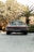 A gleaming classic car parked in a sunlit driveway, showcasing its polished exterior.