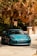 A sleek car parked in a sunlit driveway, showcasing its polished exterior.