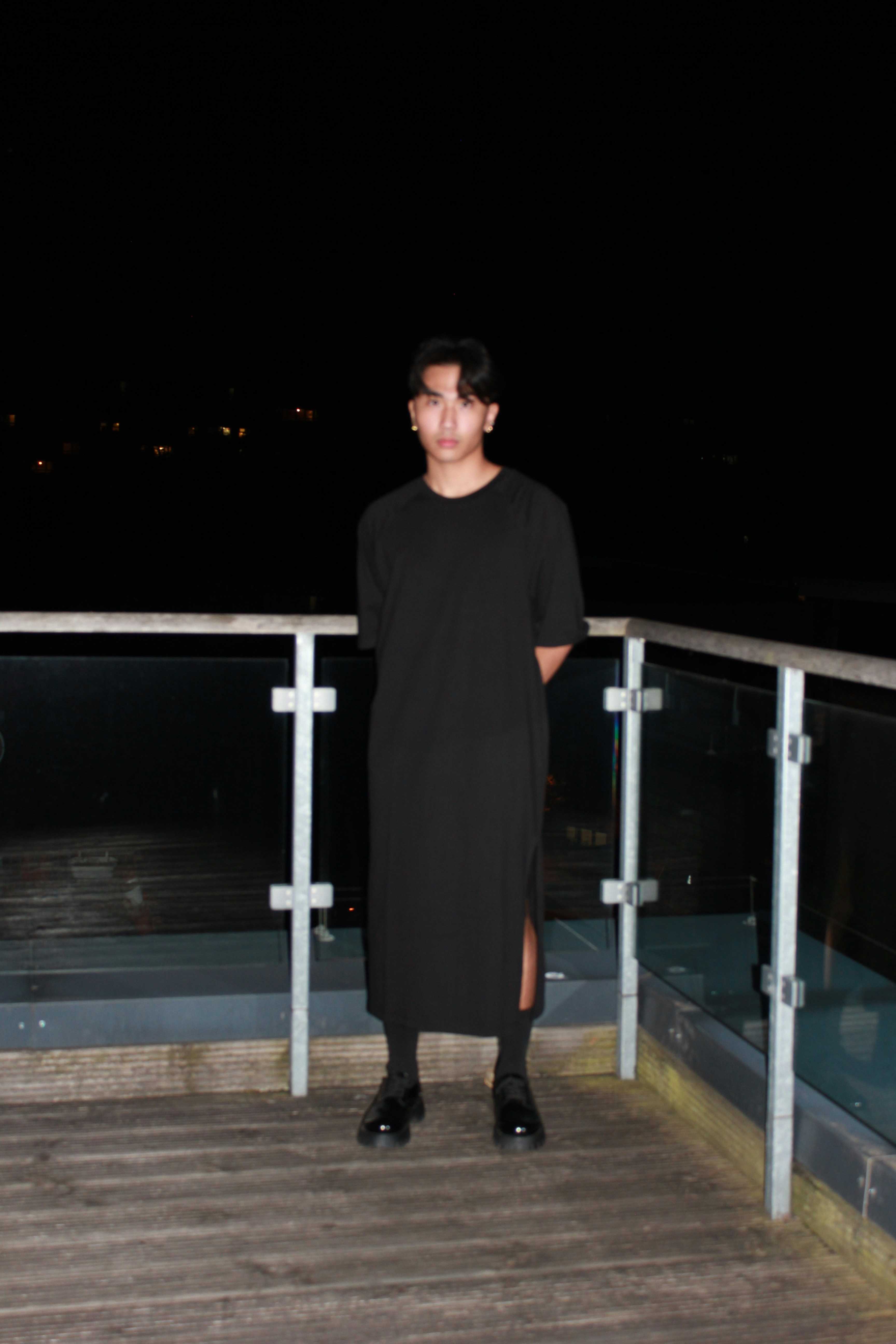 man in black long sleeve shirt standing on wooden dock during nighttime