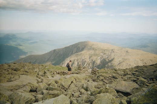 A solo traveler hiking a scenic mountain trail at sunrise.