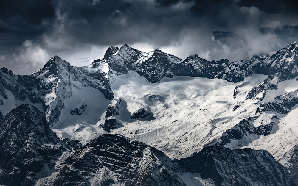 snow covered mountain under cloudy sky during daytime