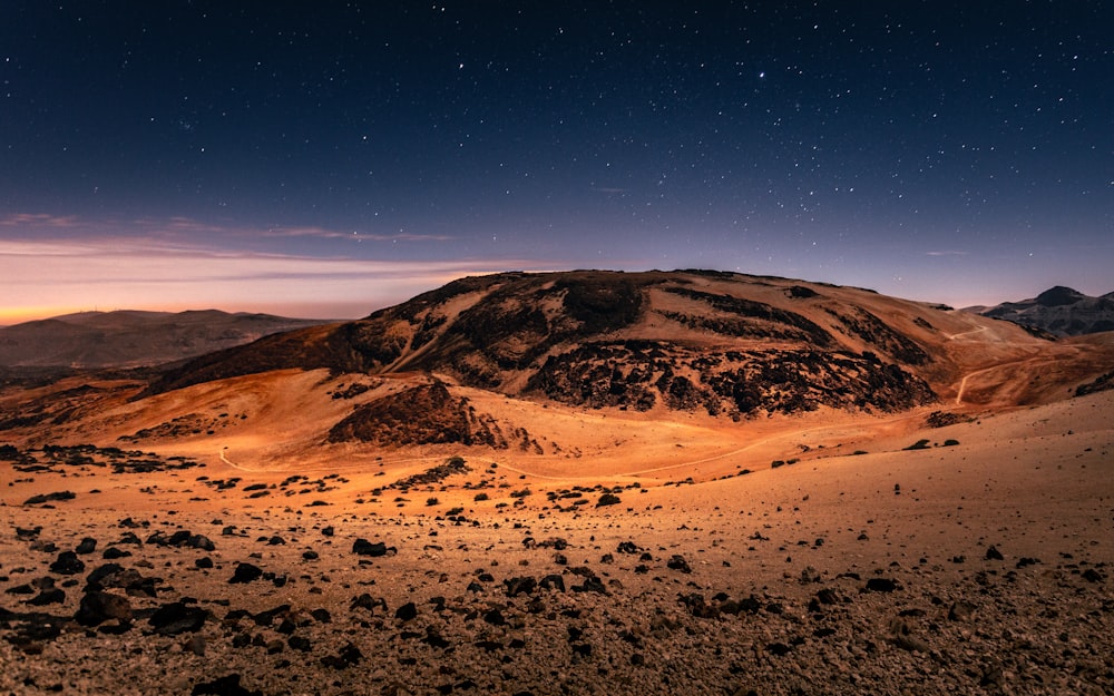 Formación rocosa marrón y negra bajo el cielo azul durante el día