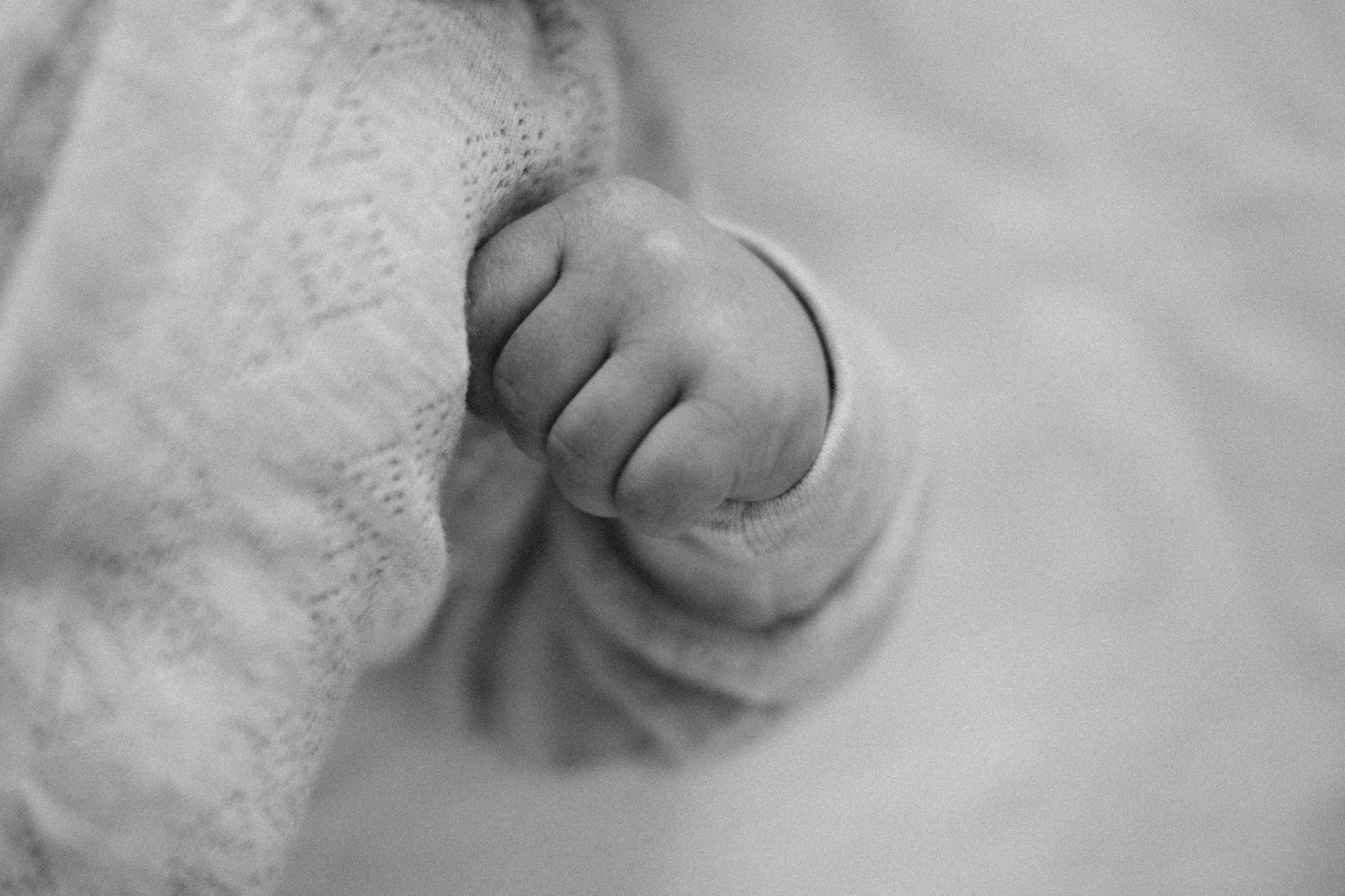Close-up of a child's hands carefully pouring water in a Montessori practical life exercise.