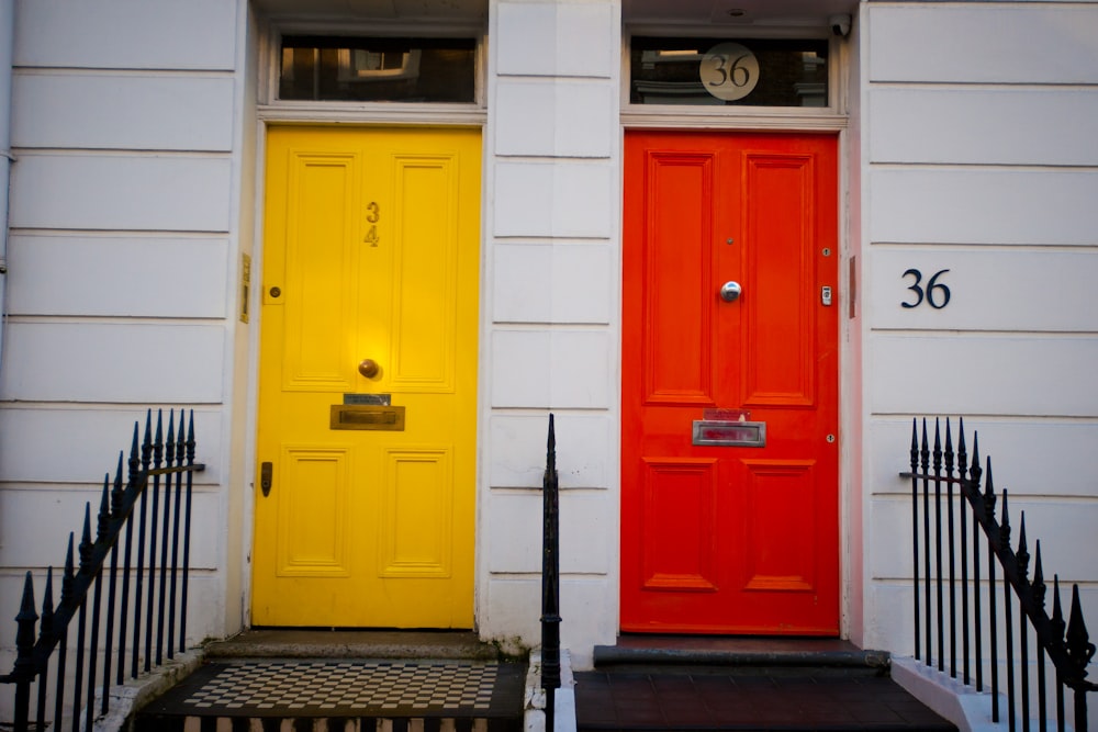 red wooden door on white concrete building