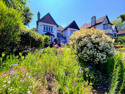 A beautifully landscaped duplex house with vibrant greenery.