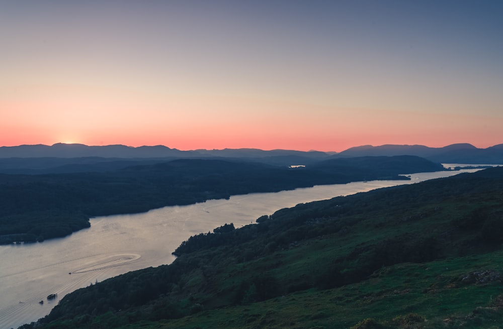 a view of a lake and mountains at sunset