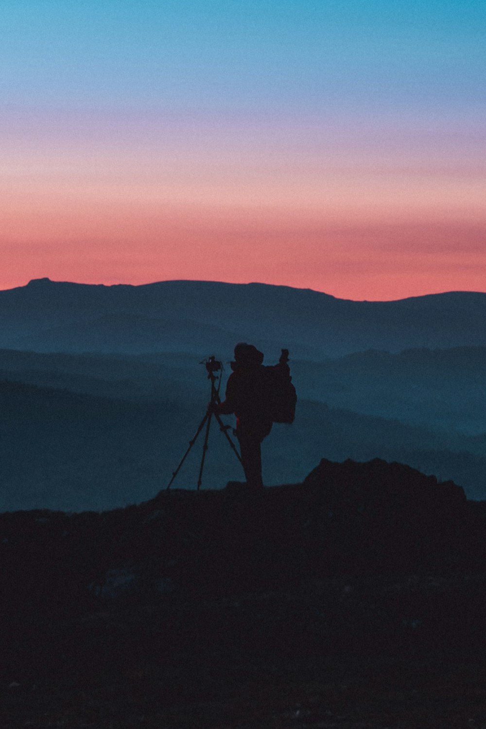 a person with a camera on top of a mountain