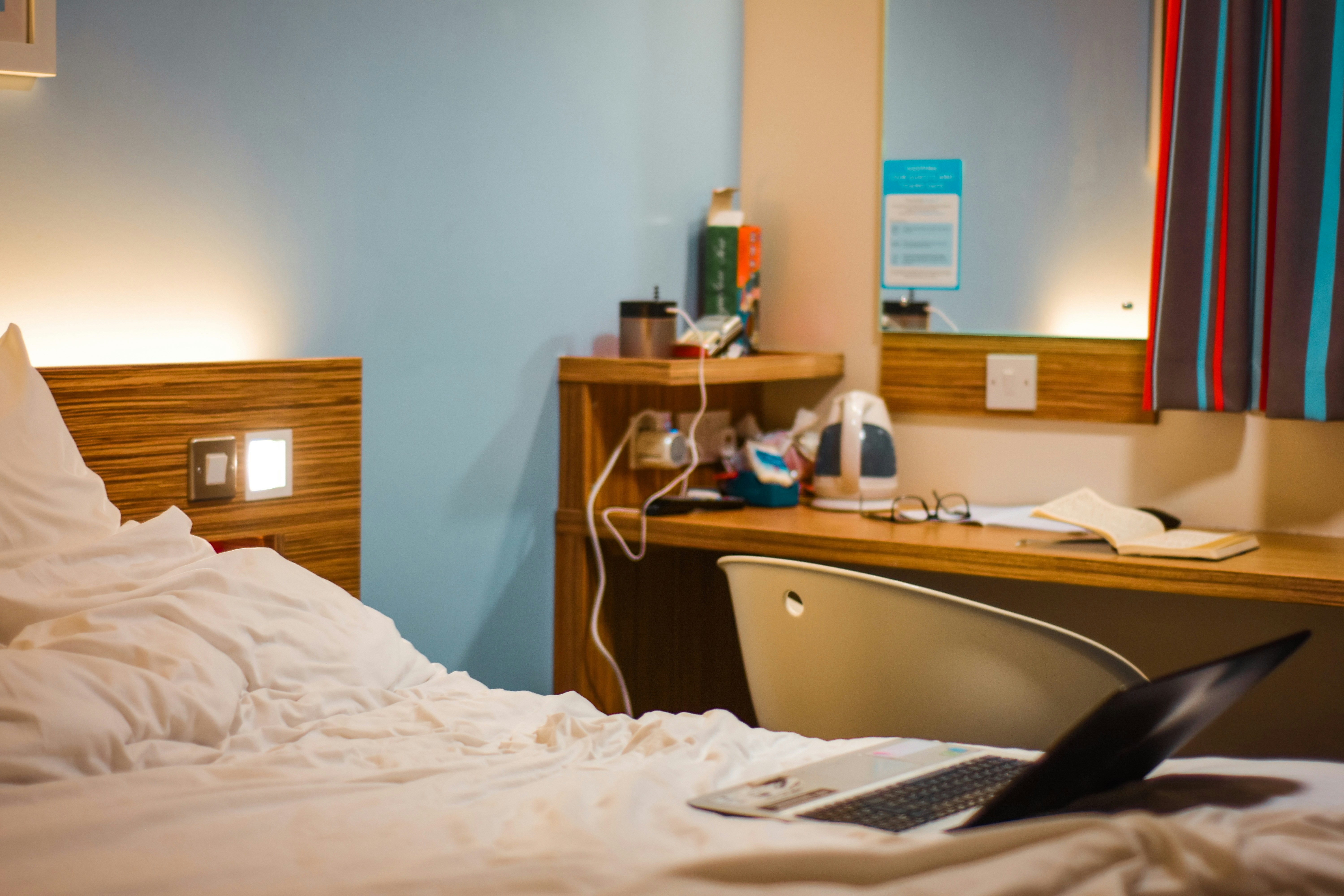 brown wooden drawer beside bed