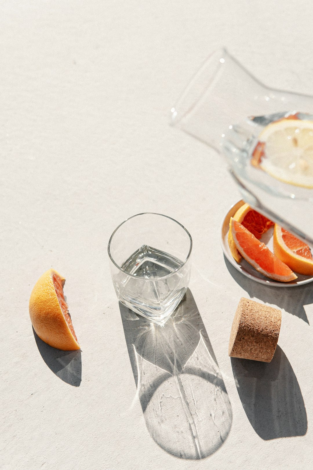 clear drinking glass beside sliced orange fruit